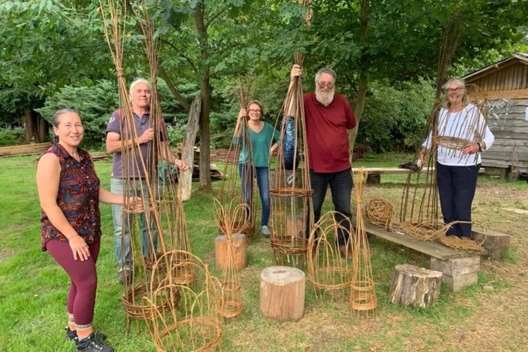 Five People on a Hedges & Hurdles Plant Support Workshop showing off their willow obelisks, domes and plant support structures made from willow. Taken at Birtley Woodland Art Space on the Birtley Estate
